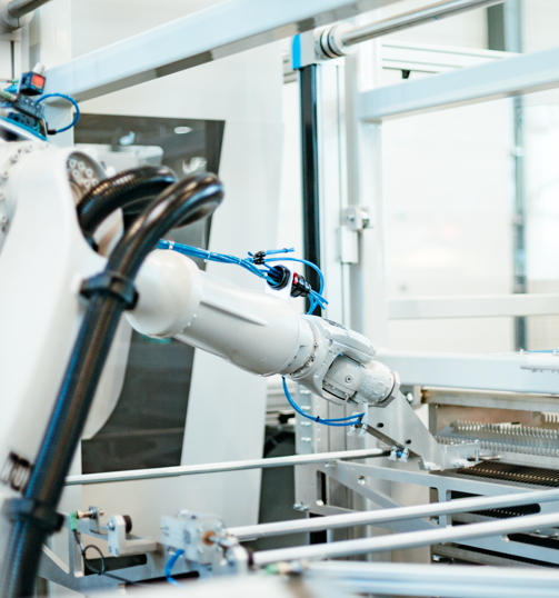 Robotic arm in a lab reaching for a tray of samples.